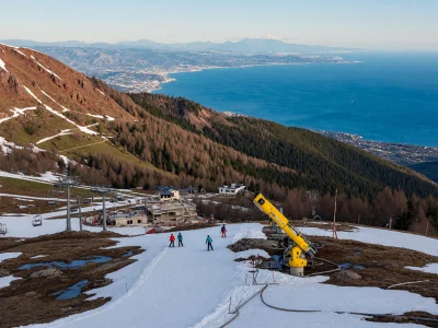 Skieurs et dameuse jaune sur les pistes enneigées de gréolières les neiges face à la mer