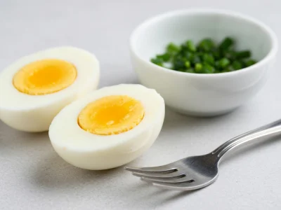 Deux moitiés d'oeuf dur, un bol d'herbes et une fourchette illustrent les calories pour un oeuf dur