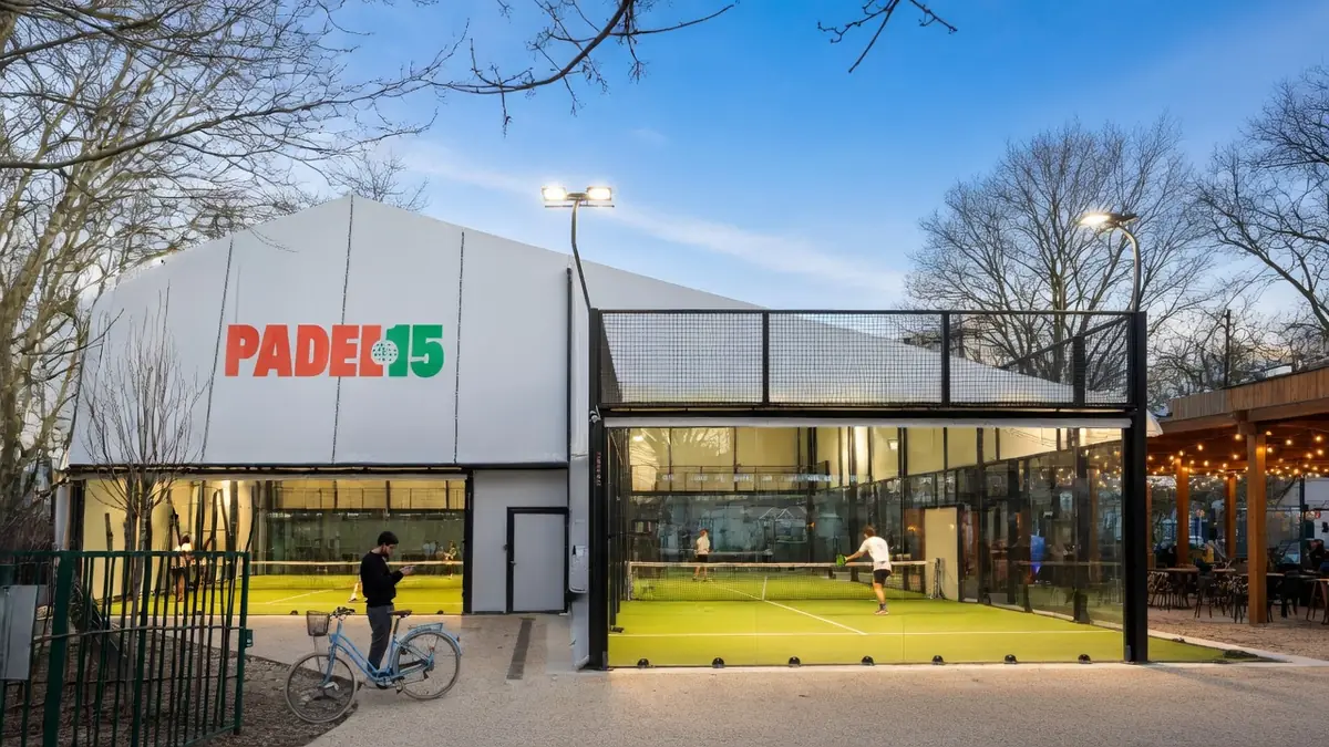 Vue extérieure du complexe sportif padel 15 avec des terrains de jeu modernes éclairés et une terrasse conviviale