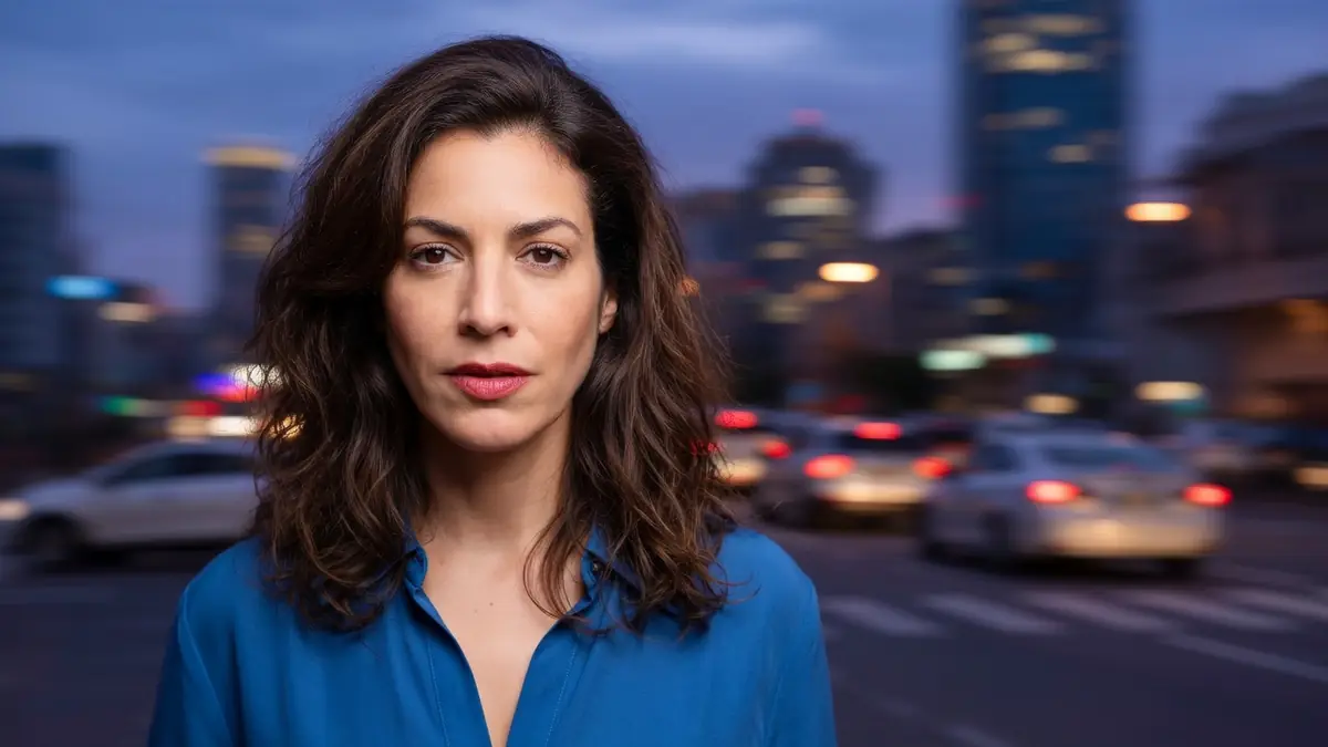 Myriam Bourguignon regarde l'objectif devant un décor urbain le soir