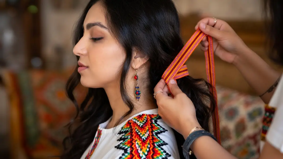 Des mains appliquent un kardoune rayé sur les cheveux d'une femme par Kardoune.fr