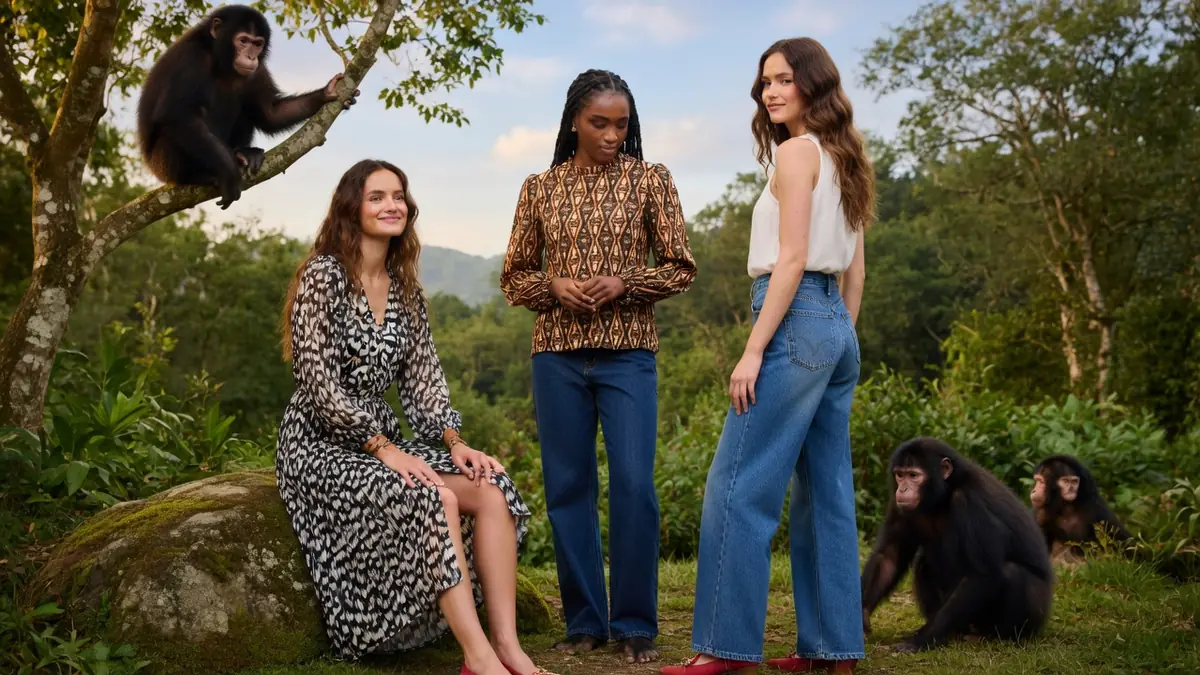 Des femmes posent avec des bonobo femme dans un cadre naturel verdoyant.