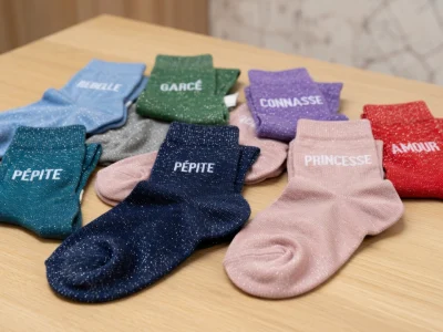 Des chaussettes à paillettes colorées sont étalées sur une table en bois