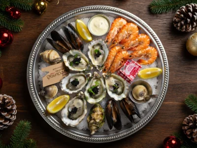 Un plateau de fruits de mer garni d'huîtres Noël et de crevettes disposé sur un lit de glace pour les fêtes