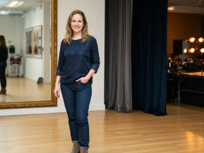 Alexie Ribes se tient dans un studio de théâtre, son reflet visible dans le miroir.
