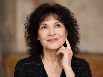 Marianne Épin lève les yeux avec un sourire et la main sur le menton