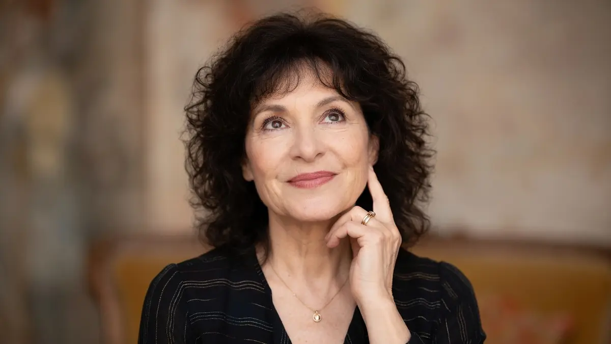 Marianne Épin lève les yeux avec un sourire et la main sur le menton
