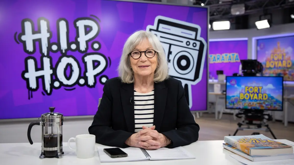 Marie-France Brière est assise à un bureau dans un plateau de télévision