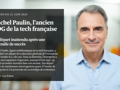 Michel Paulin sourit en chemise bleue sur fond verdoyant flou