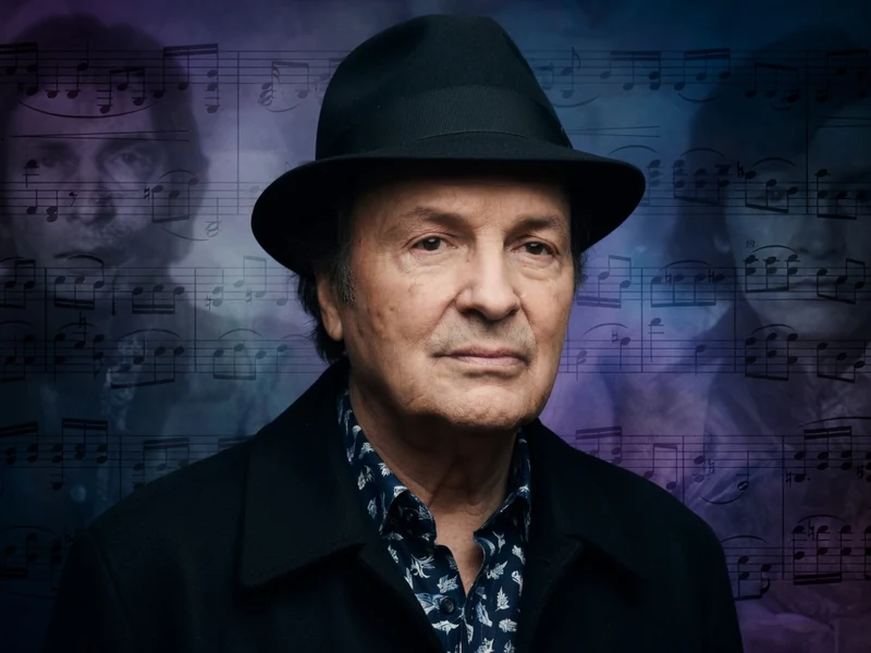 Michel Tabachnik est photographié avec un chapeau noir sur fond de notes de musique