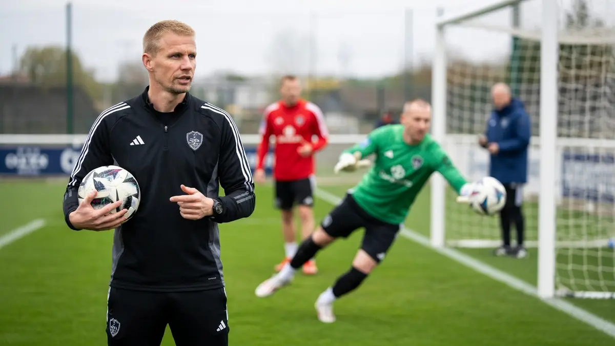 Olivier Blondel observe un gardien plongeant pour saisir le ballon sur le terrain