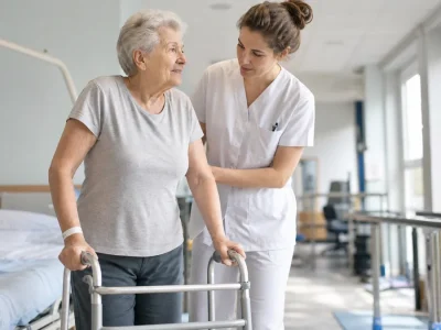 Rééducation à l’hôpital après une chirurgie du col fémoral chez une patiente âgée.