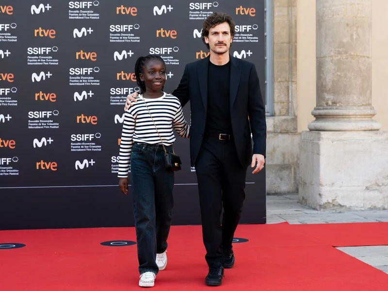 Oumy Bruni Garrel marche sur un tapis rouge aux côtés de l'acteur Louis Garrel