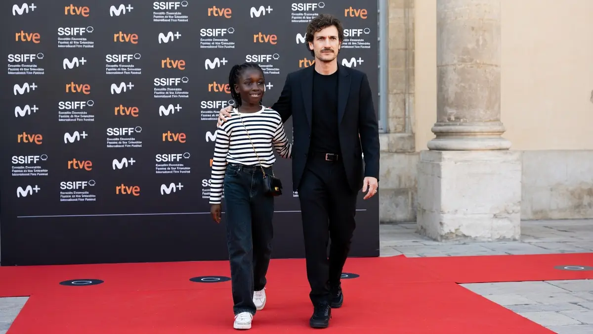 Oumy Bruni Garrel marche sur un tapis rouge aux côtés de l'acteur Louis Garrel