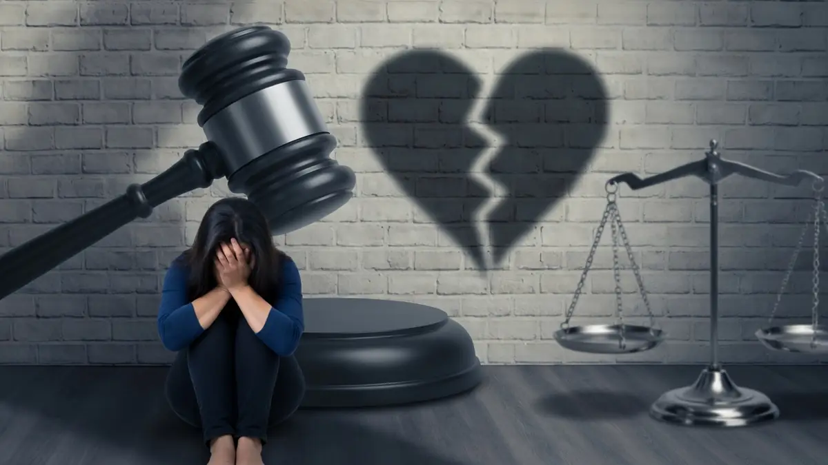 L'image illustre la peine pour violence conjugale par une femme effondrée devant un marteau et un cœur brisé