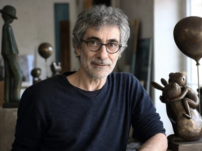 Philippe Berry pose dans son atelier auprès d'une sculpture en bronze inspirée de l'enfance.