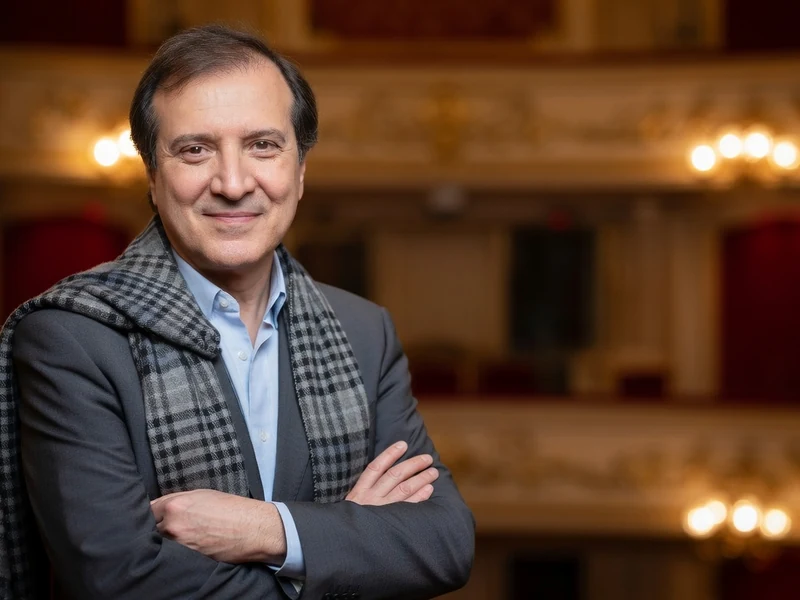 Philippe Uchan se tient les bras croisés avec une écharpe dans un théâtre