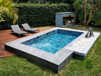 Une piscine rectangulaire dans un jardin avec transats sur une terrasse en bois au prix piscine 10m2 tout compris