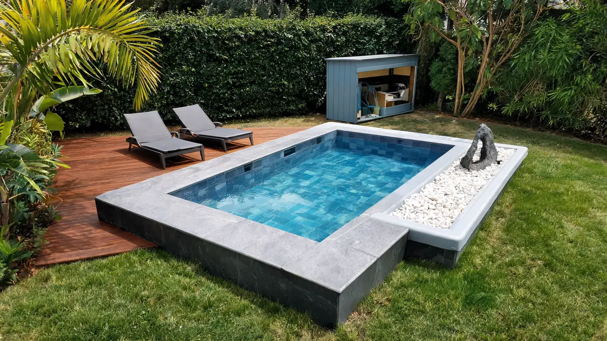Une piscine rectangulaire dans un jardin avec transats sur une terrasse en bois au prix piscine 10m2 tout compris