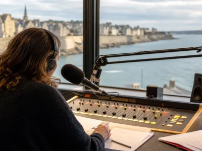 Une animatrice prépare une émission de radio bleue Breizh Izel face au littoral breton.