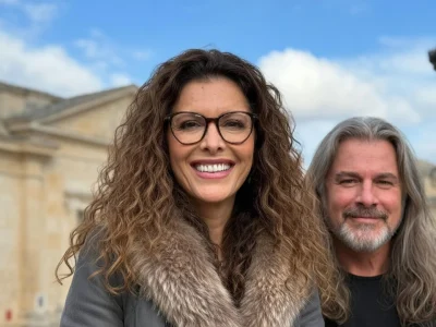 Portrait souriant de Sabrina Gunnell posant à côté d'un homme devant un bâtiment historique en pierre