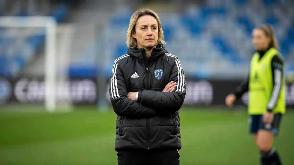 Sandrine Soubeyrand se tient les bras croisés sur le terrain de football