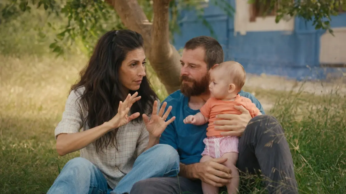 Une femme communique en langue des signes avec son compagnon portant leur bébé dans le film Sorda