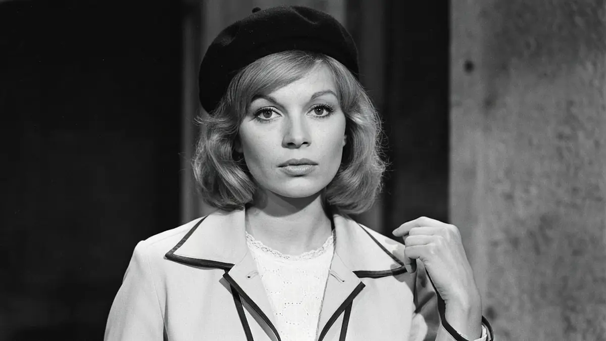 Sylvia Saurel pose en noir et blanc avec un béret et une veste claire