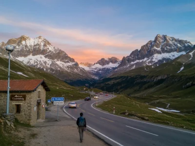 La webcam Pourtalet montre un randonneur marchant près d'une route de montagne bordée de sommets enneigés