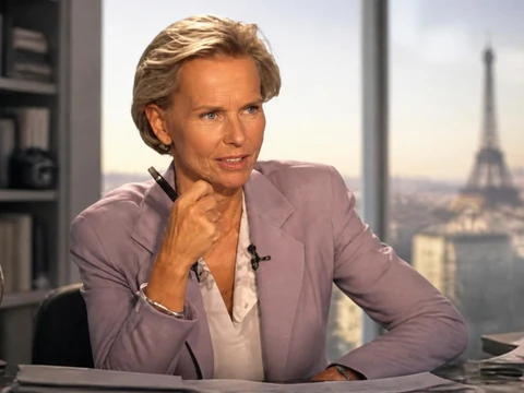 Portrait de la journaliste Christine Ockrent posant à son bureau avec la tour Eiffel en arrière-plan