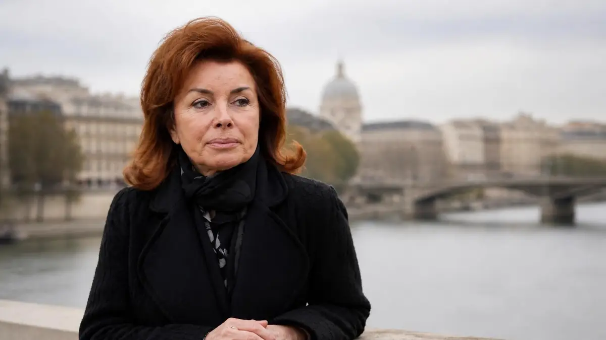 Dominique Tapie pose avec sérieux devant la Seine à Paris