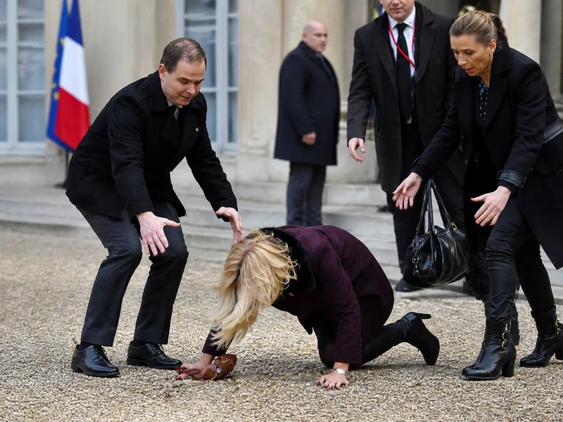 Une personne ressemblant à la Première dame est au sol dans une scène évoquant la chute Brigitte Macron