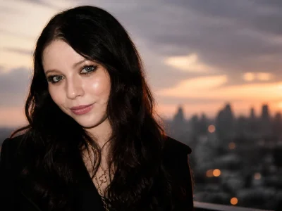 Portrait de l'actrice Michelle Trachtenberg souriant devant un coucher de soleil sur la ville