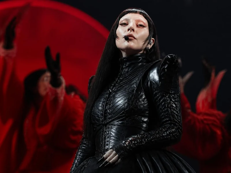 Lady Gaga en tenue de scène noire lors de son mémorable Lady Gaga tour Paris entourée de danseurs en rouge