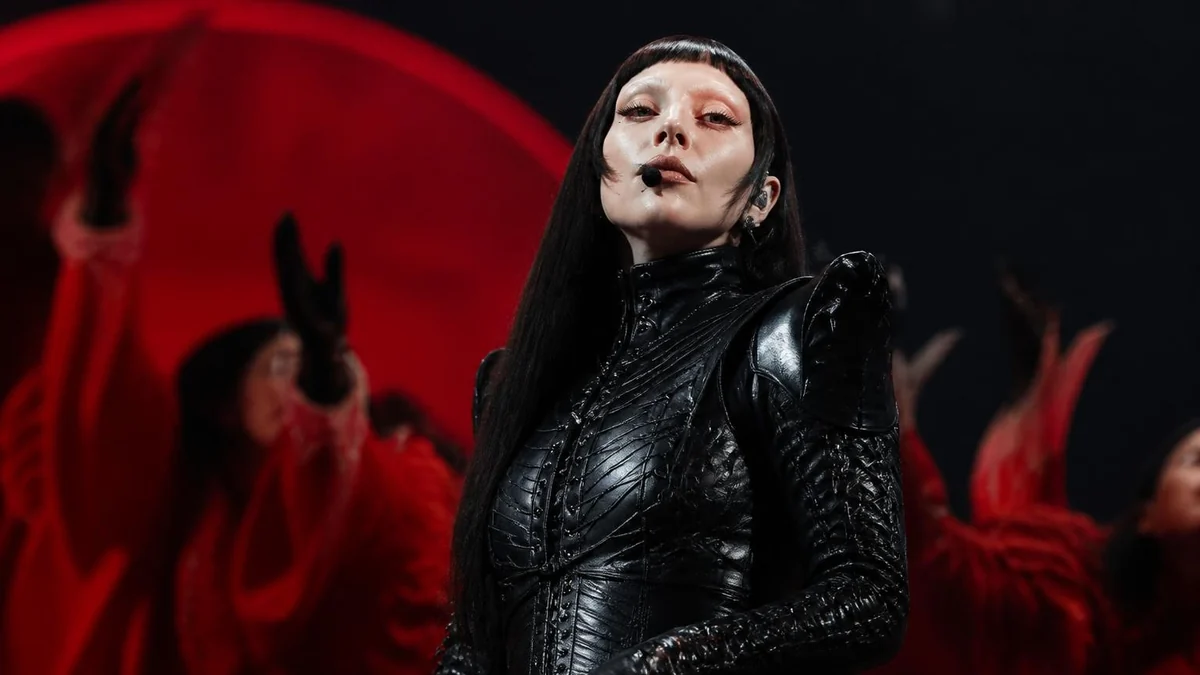 Lady Gaga en tenue de scène noire lors de son mémorable Lady Gaga tour Paris entourée de danseurs en rouge