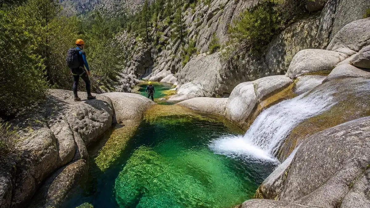 Canyoning dans une magnifique piscine naturelle du Canyon aux eaux cristallines entourée de rochers en Corse