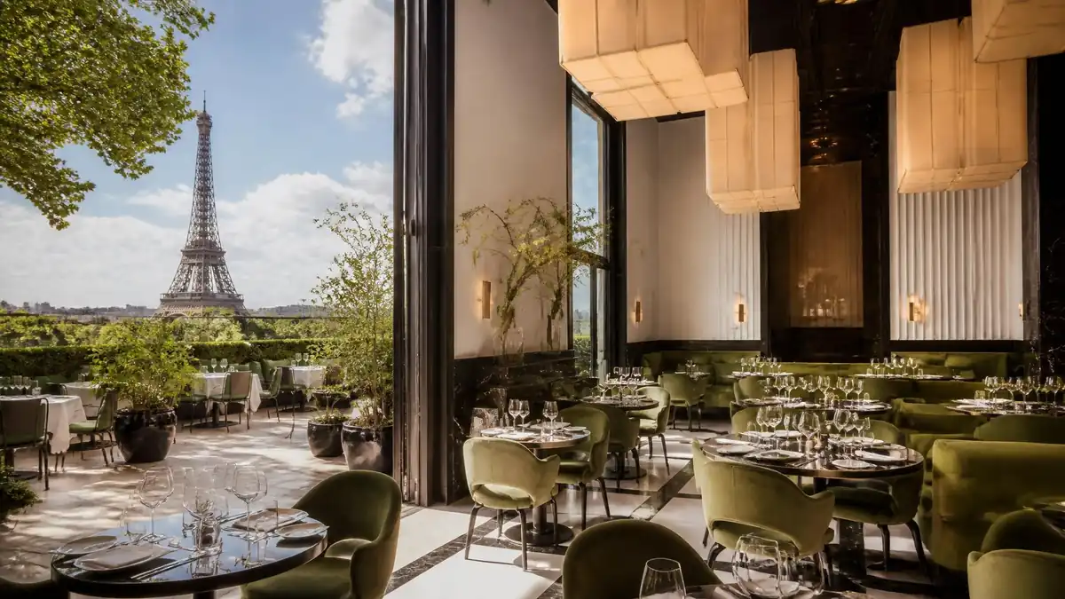 Vue élégante de la terrasse et de la salle intérieure du restaurant Monsieur Bleu avec la tour Eiffel en arrière-plan