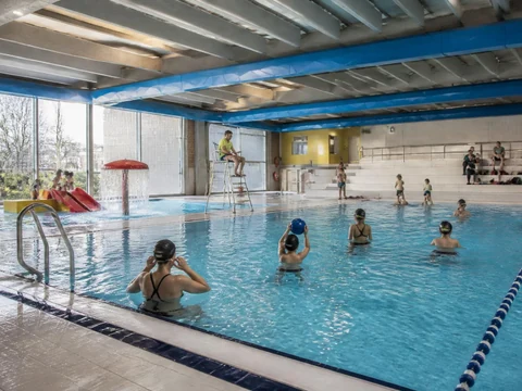 Baigneurs profitant d'un bassin intérieur lumineux au sein de la Léo Lagrange piscine