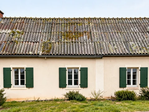 Maison ancienne avec un toit en fibrociment nécessitant de savoir reconnaître amiante pour évaluer les risques
