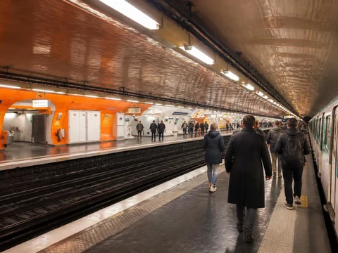Des passagers marchent sur le quai de la station Havre-Caumartin avec un métro à l'arrêt