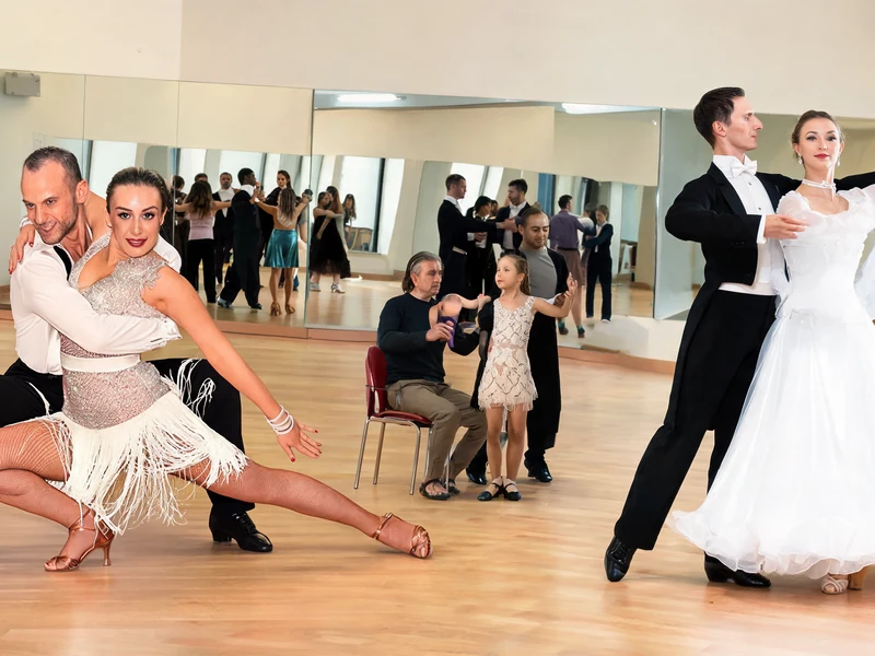 Des couples élégants pratiquent une danse de salon cours dans une salle de danse avec des miroirs