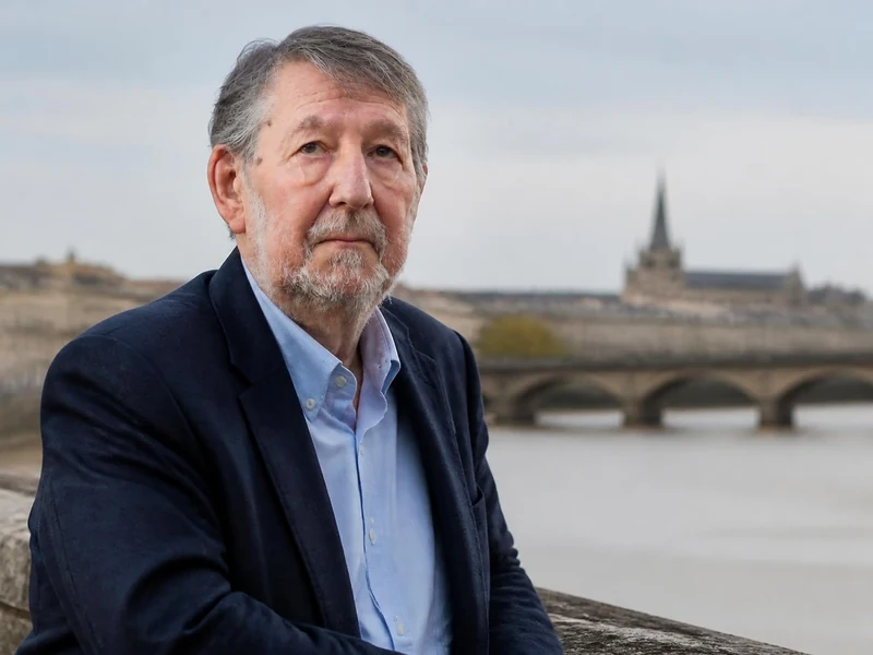 Portrait de l'homme politique Alain Anziani posant devant le pont de pierre à Bordeaux