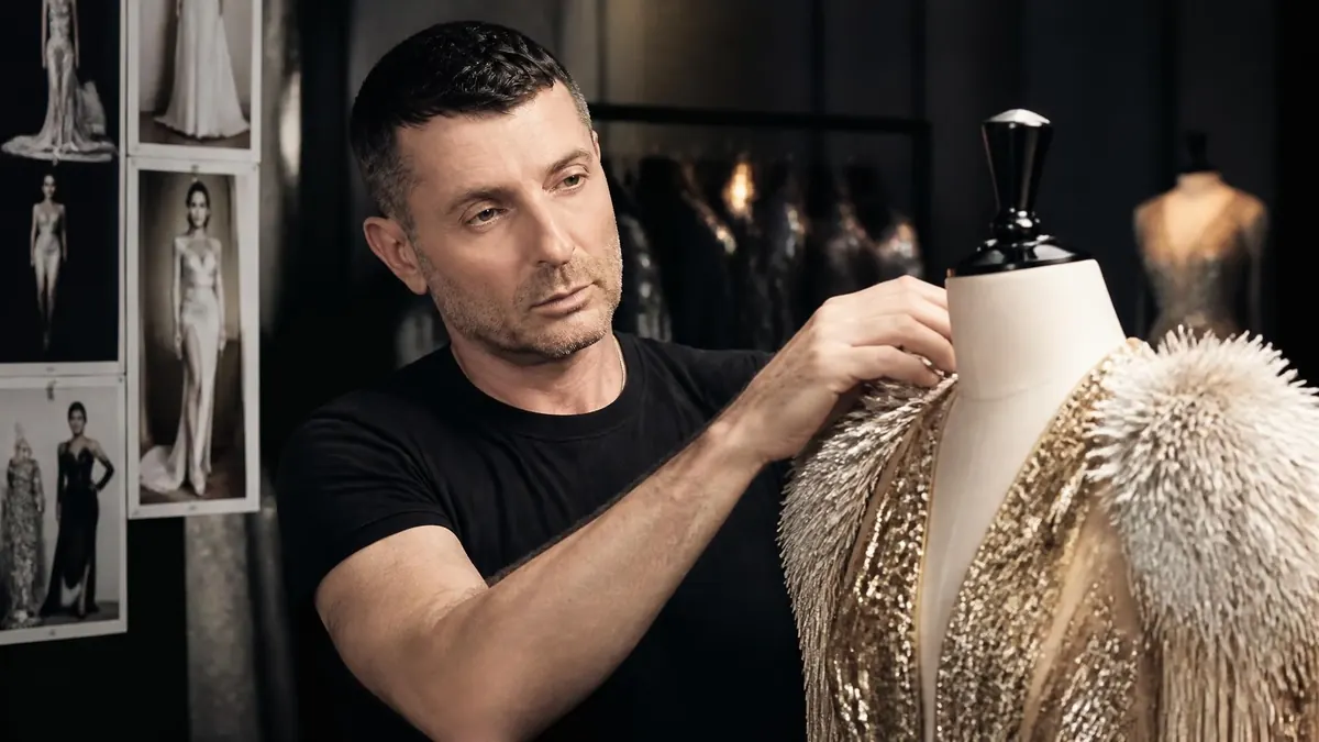 Le créateur Alexandre Vauthier ajuste avec précision une robe de haute couture sur un mannequin de couture dans son atelier