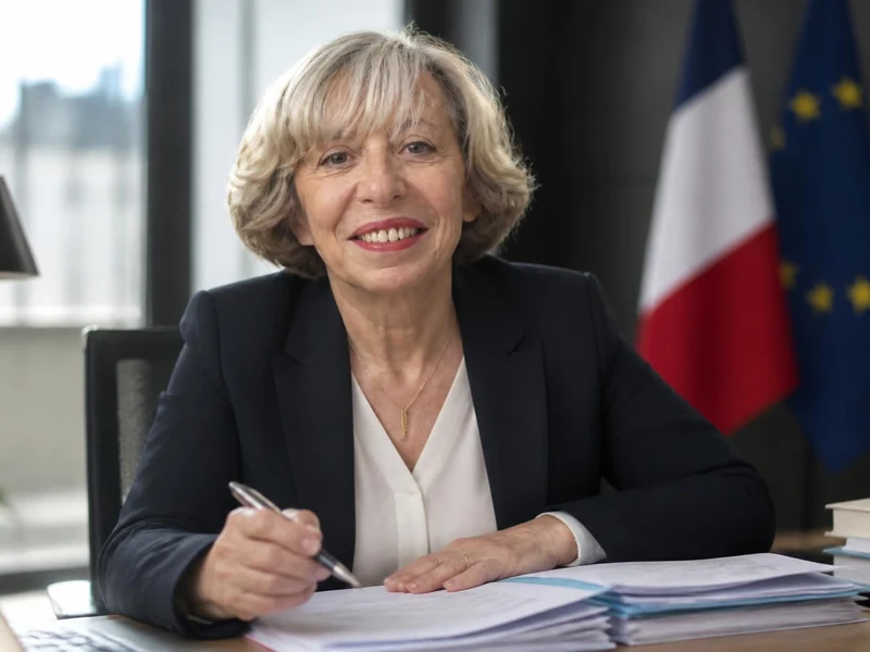 Portrait professionnel de l'économiste Anne Perrot souriant à son bureau
