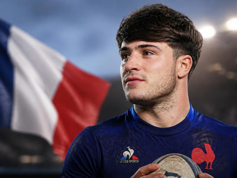 Portrait du jeune rugbyman Axel Desperes devant le drapeau français avec un ballon de rugby