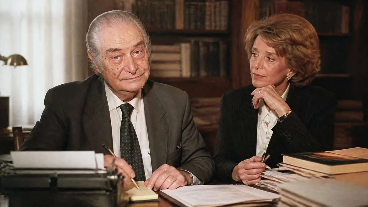 Un homme et une femme en tenue professionnelle travaillent ensemble dans un bureau, évoquant la figure de Claude faux