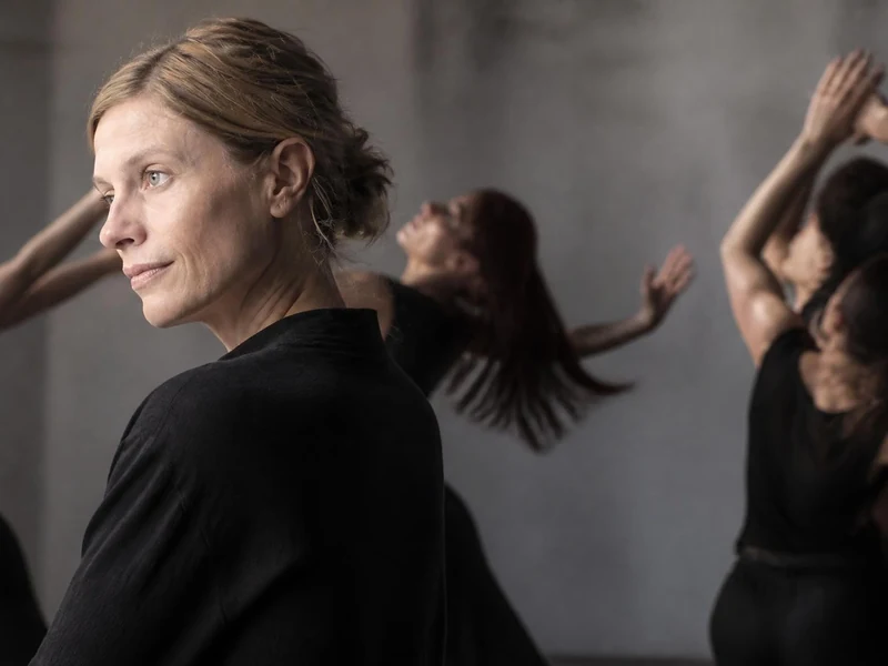 La chorégraphe Crystal Pite observe ses danseurs en répétition dans un studio au ton gris et feutré