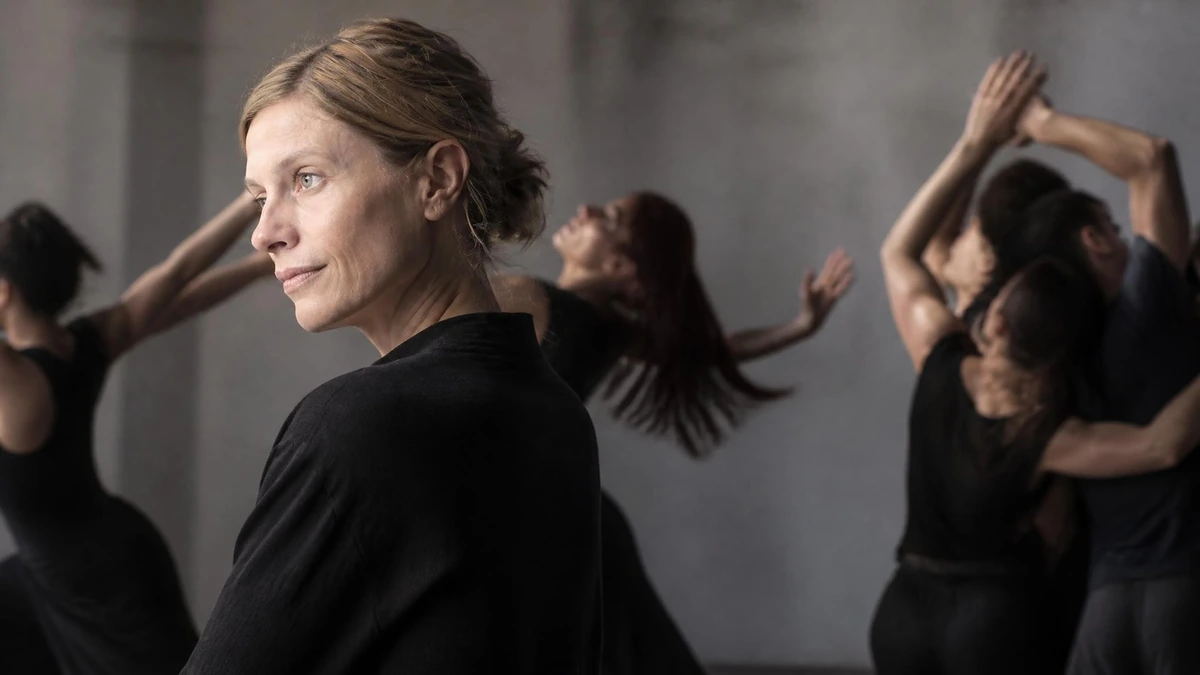 La chorégraphe Crystal Pite observe ses danseurs en répétition dans un studio au ton gris et feutré