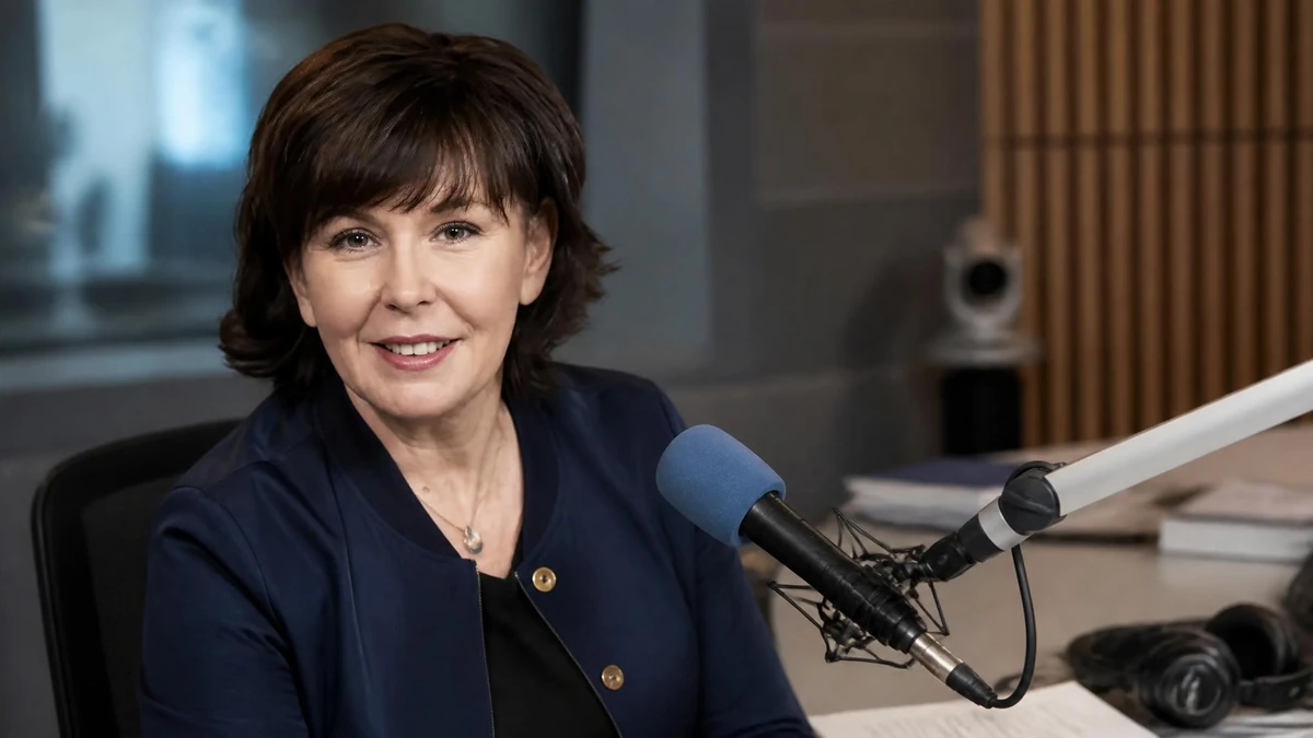 Portrait souriant de la journaliste Isabelle Quenin installée devant un micro dans un studio de radio