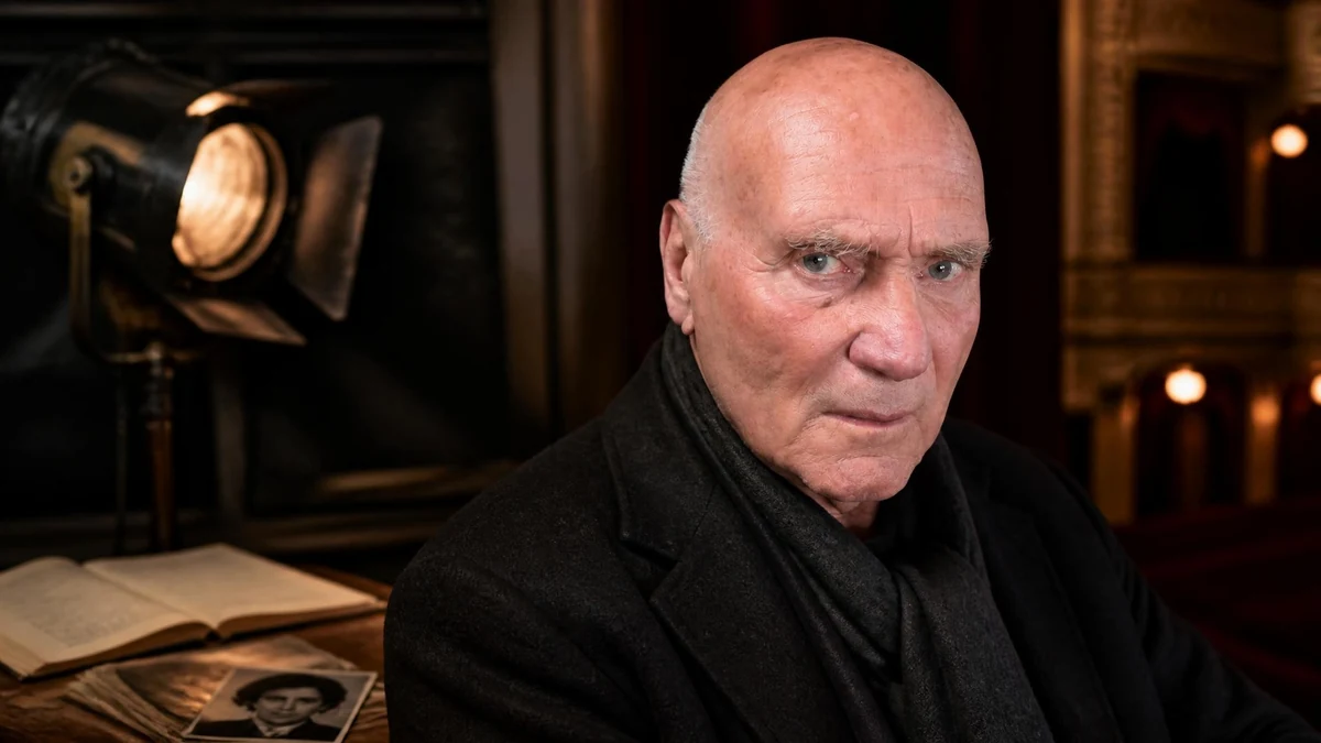 Portrait de l'acteur Jean-Paul Zehnacker posant dans un décor de théâtre sombre éclairé par un projecteur